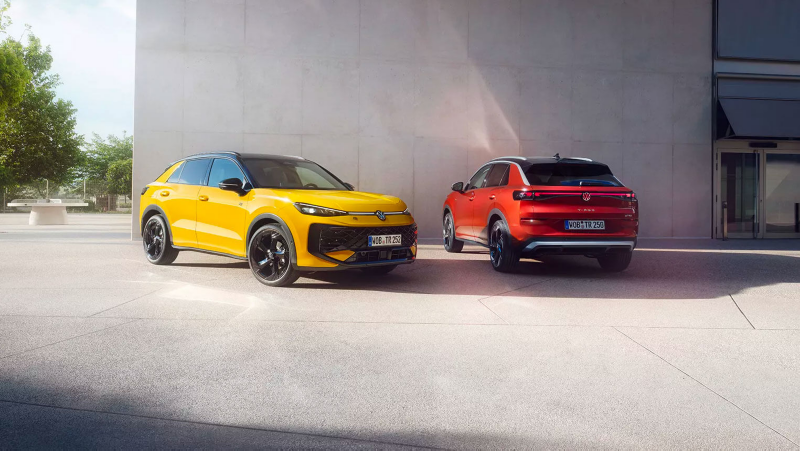 Un VW T-Roc R-Line jaune et un VW T-Roc Style rouge côte à côte devant un bâtiment moderne.