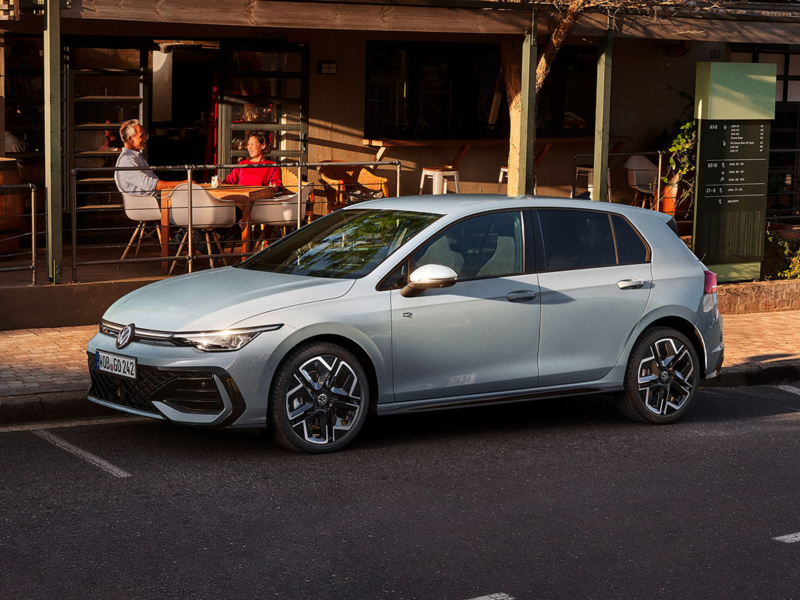 Une Golf R-Line grise de profil, garée devant un restaurant.