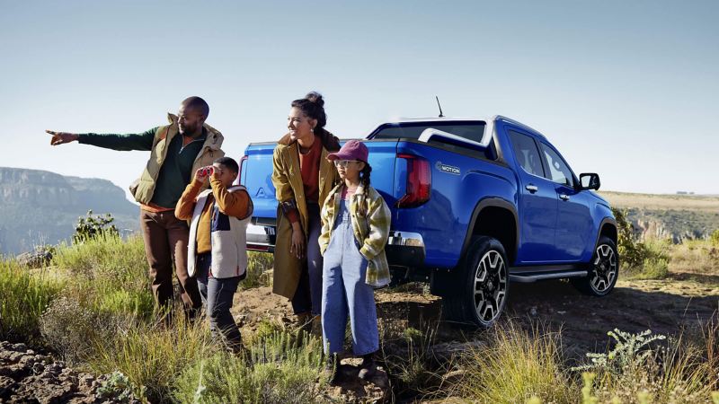 Familia en el campo junto a camioneta pickup VW Amarok