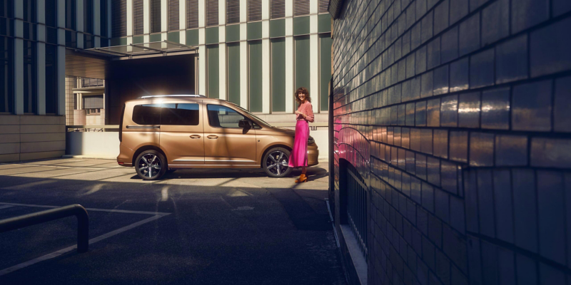 Vista lateral del VW Caddy Pasajeros 2023 en calles de la ciudad