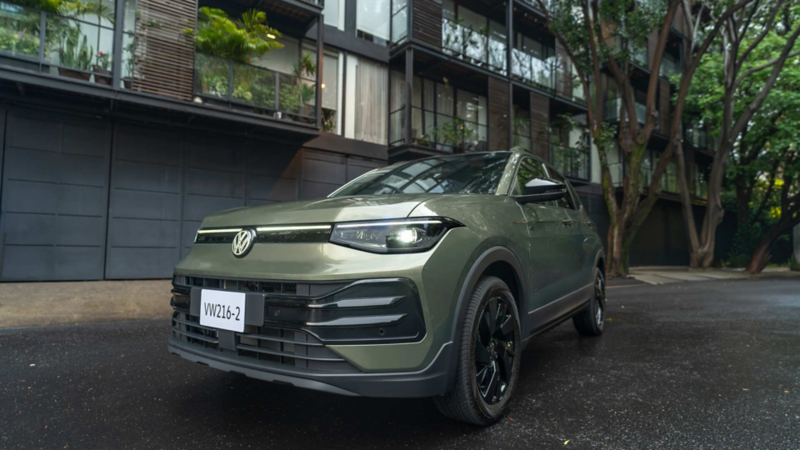 Nuevo Taigun 2026 verde estacionado frente a un edificio moderno con plantas.