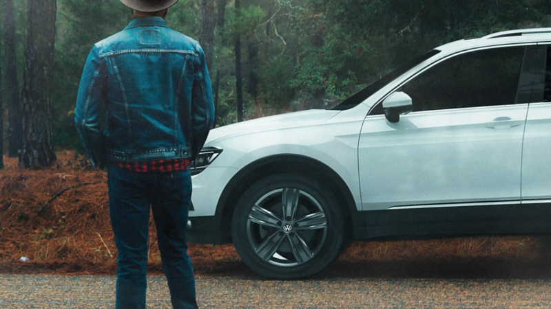 Hombre parado frente a Tiguan 2020, SUV familiar reconocida por su seguridad y tecnología