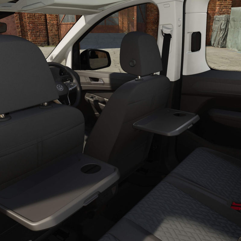 interior of a VW Caddy showing the fold-out tables in the backseat