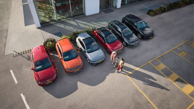 Volkswagen occassiosns naast elkaar op een parkeerplaats met een gezin