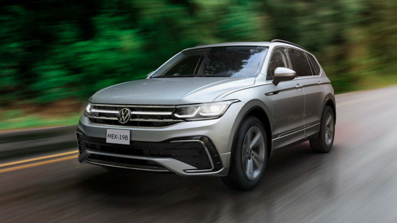 Camioneta Tiguan de color plata transita sobre carretera mojada por la lluvia. 