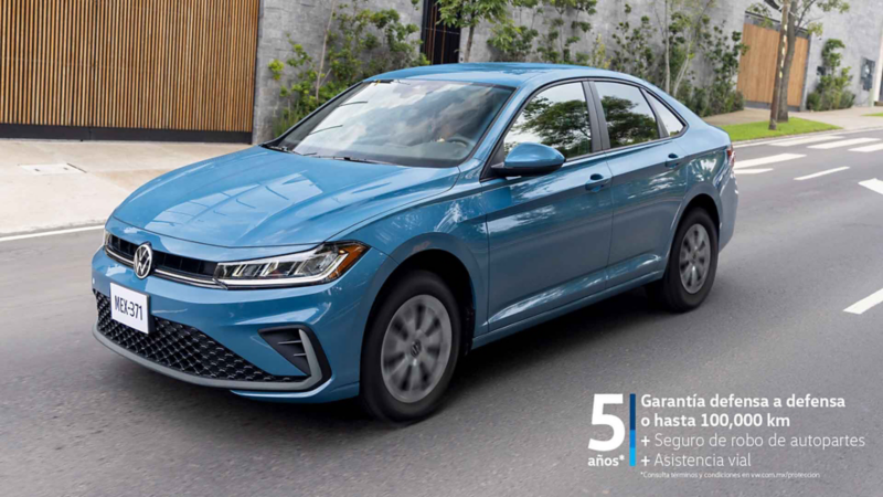 Jetta 2025 en color azul circula sobre avenida en zona residencial.