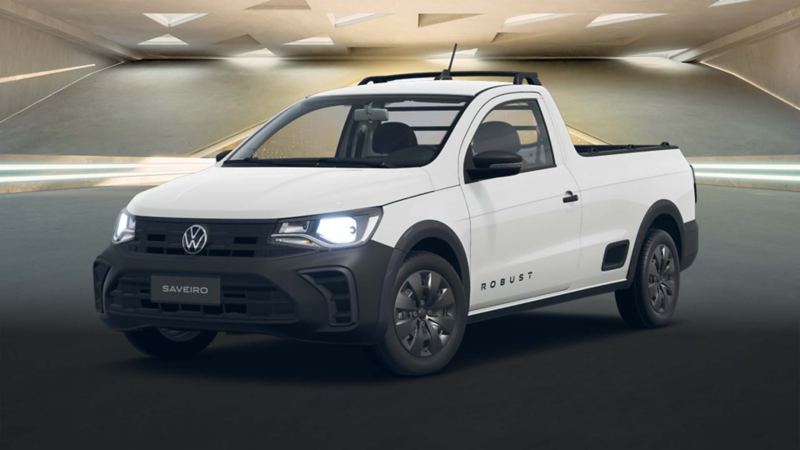 Volkswagen Saveiro 2025 en color blanco, dentro de un edificio moderno con ventilas de forma triangular. 