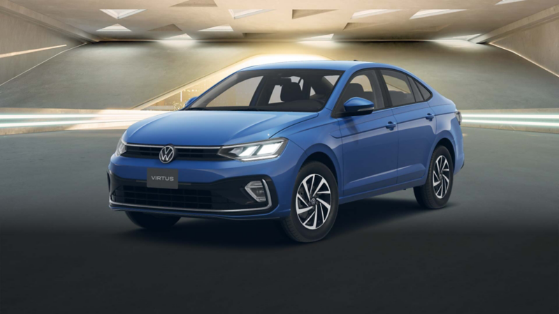 Volkswagen Virtus 2025 en color azul, dentro de un edificio moderno con ventilas de forma triangular. 