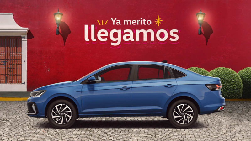 Volkswagen Virtus de color exterior azul, estacionado a las afueras de una casa colonial. 