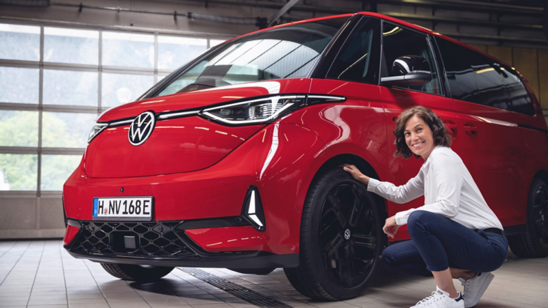 Una persona trabajadora de Volkswagen como Servicio Posventa con una ID. Buzz roja