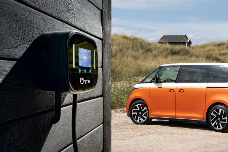 ID.Buzz parked next to a house with an Ohme charging station