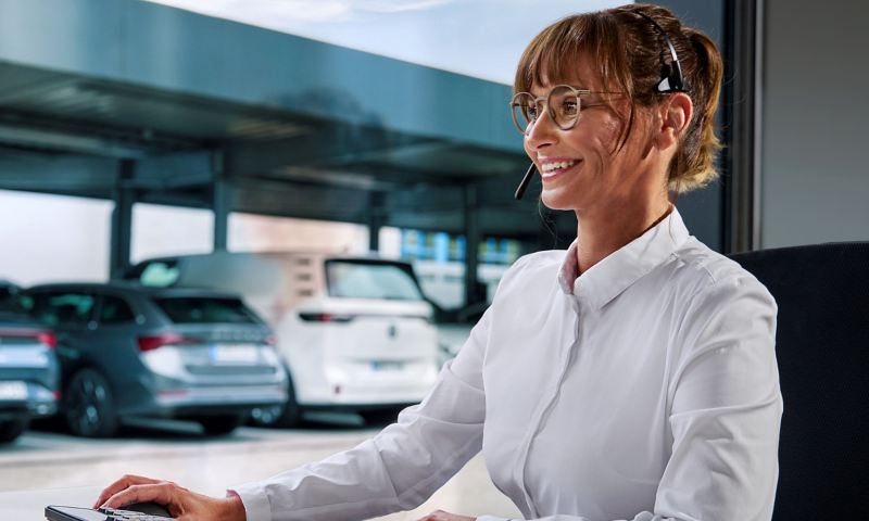 A woman with a headset on and a monitor in front of her