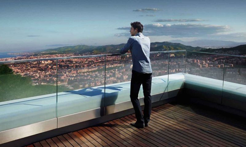 Un uomo guarda il panorama di una città dal tetto di un edificio