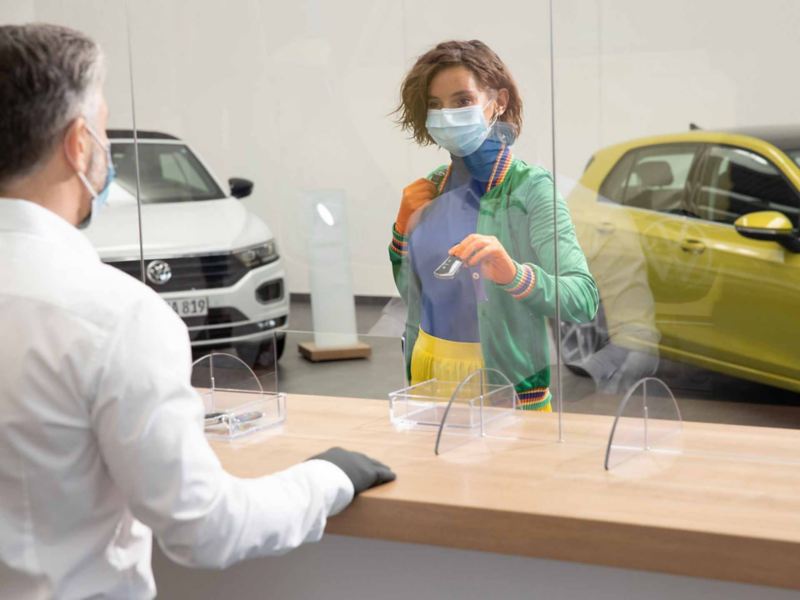 Una donna consegna le chiavi dell'auto ad un addetto presso un centro Volkswagen Service.