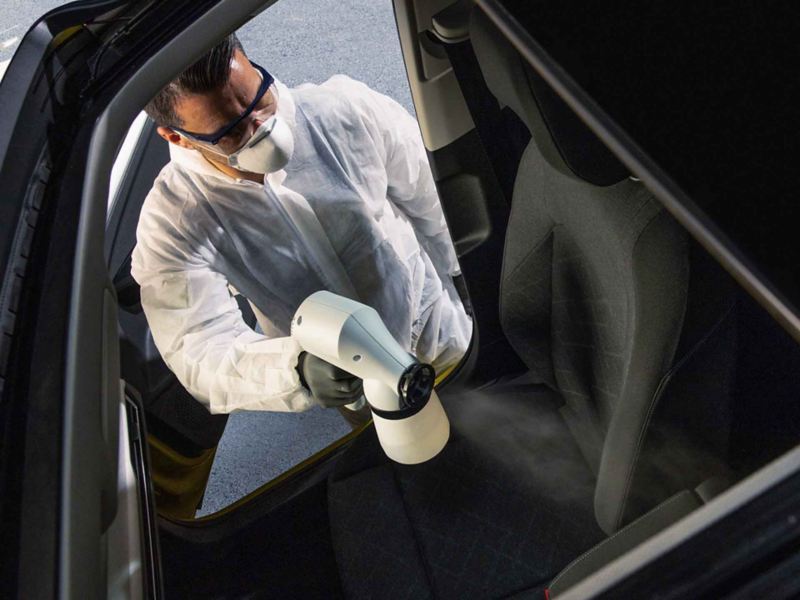 Un addetto di Volkswagen Service mentre effettua l'igienizzazione degli interni dell'auto.