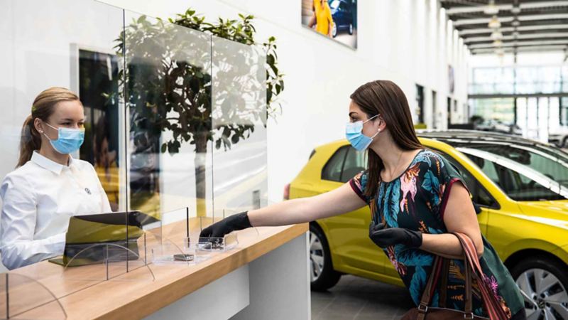 Una donna consegna le chiavi dell'auto ad un addetto presso un centro Volkswagen Service senza alcun contatto.