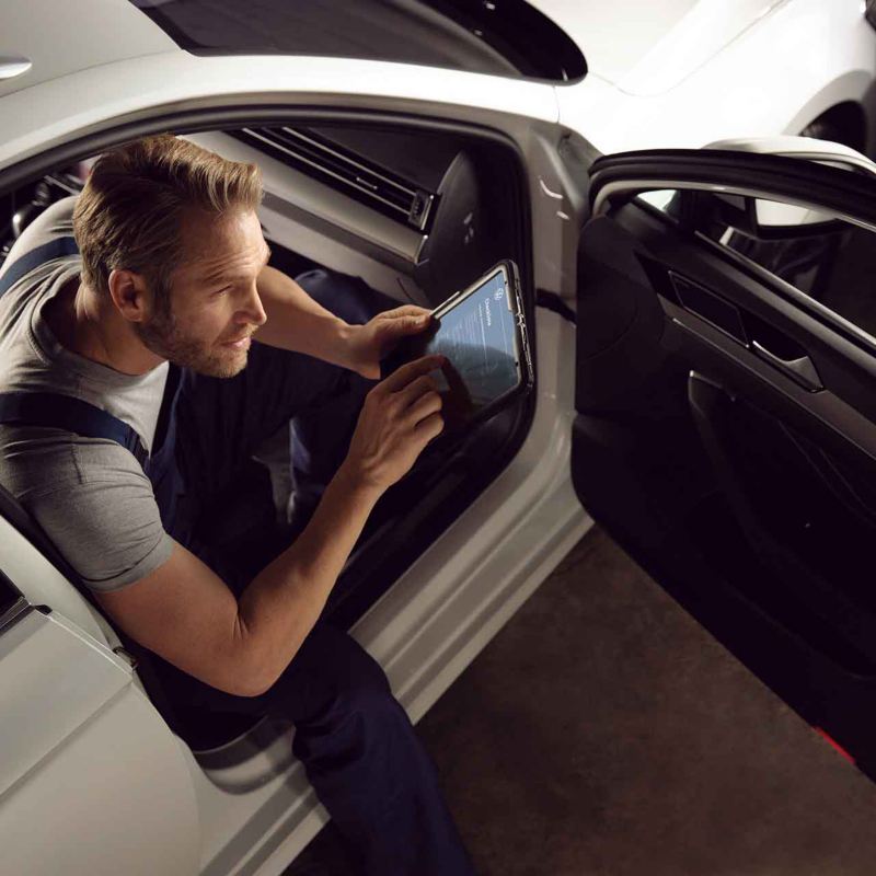 Un meccanico di un centro Volkswagen Service esegue un'ispezione all'interno di un'auto
