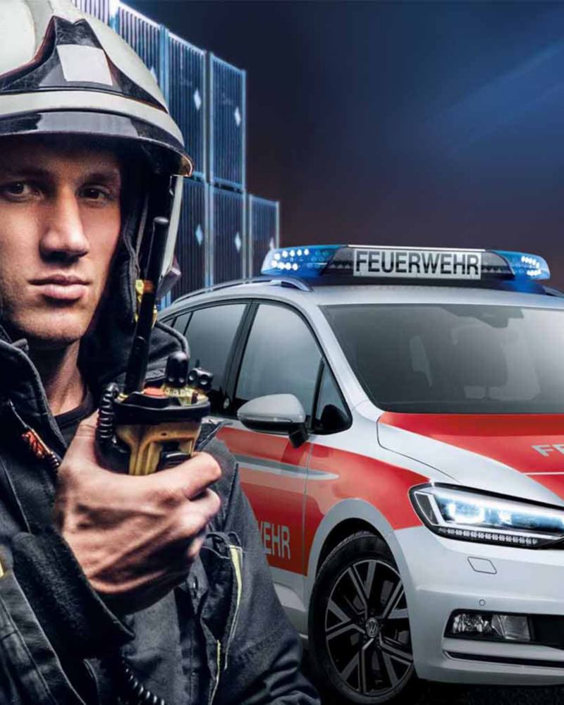 Un vigile del fuoco davanti alla sua Volkswagen adibita ad auto di emergenza, pronto a intervenire in caso di necessità