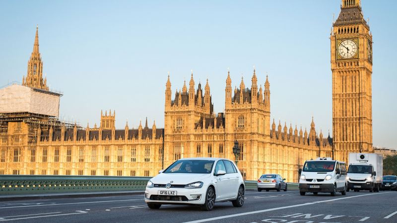 A Golf GTE on a London road the Palace of Westminster