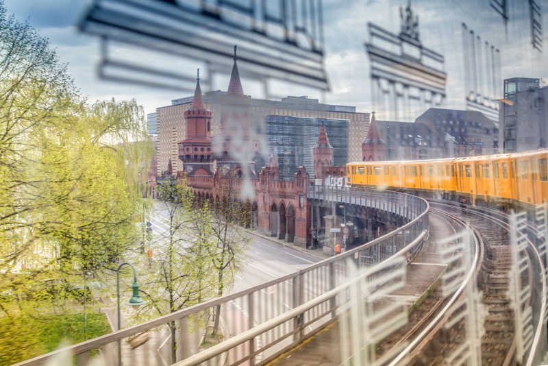 A yellow train bends around an elevated track into the distance