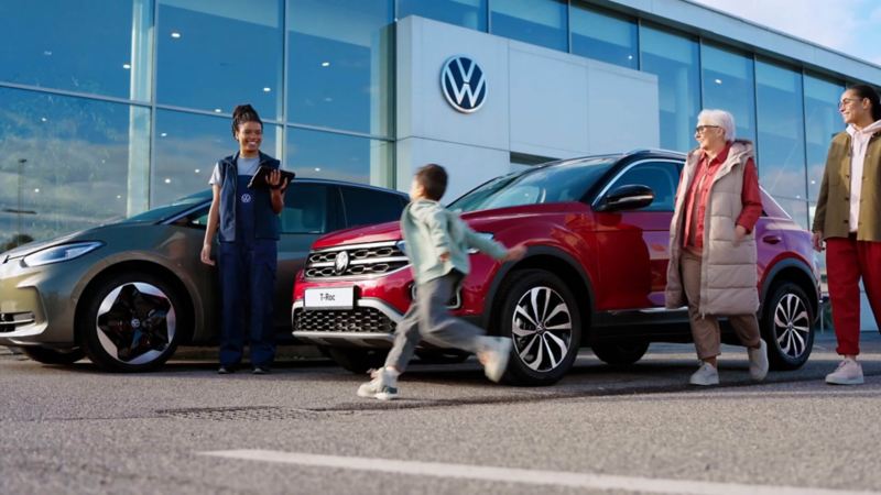 A family in the grounds of a Volkswagen retailer