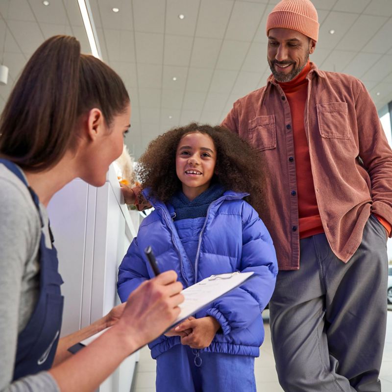 A father and daughter with a VW service expert