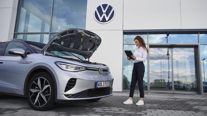 Volkswagen service employee inspects the heat pump of a VW car