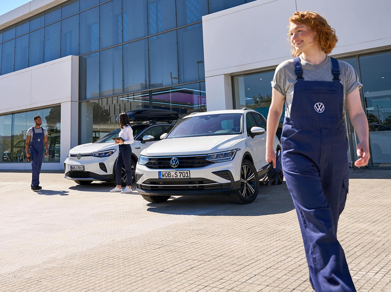 A Volkswagen technician walking in front of a retailer