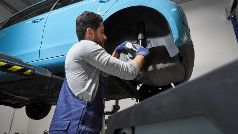 VW service employee checking the brake disc of a VW eUp!