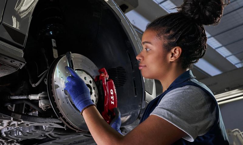 A VW service expert fitting a brake pad