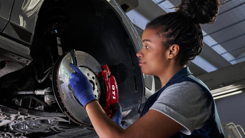 A VW service expert fitting a brake pad