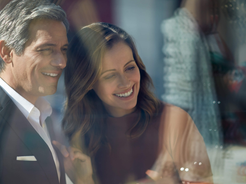 A couple smiling outside a shopfront.