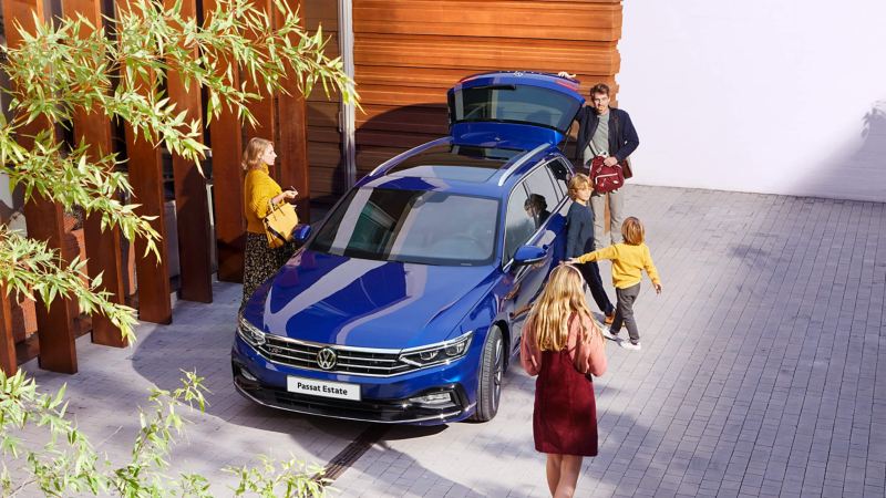 A family standing getting ready to enter a Passat Estate car