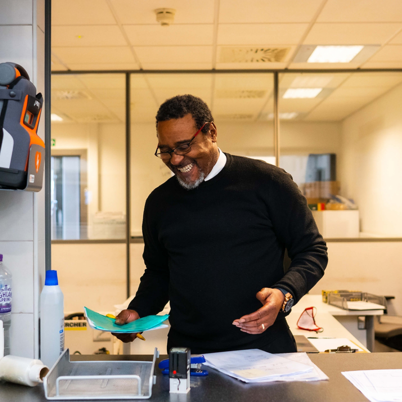 A service manager smiling looking at paperwork