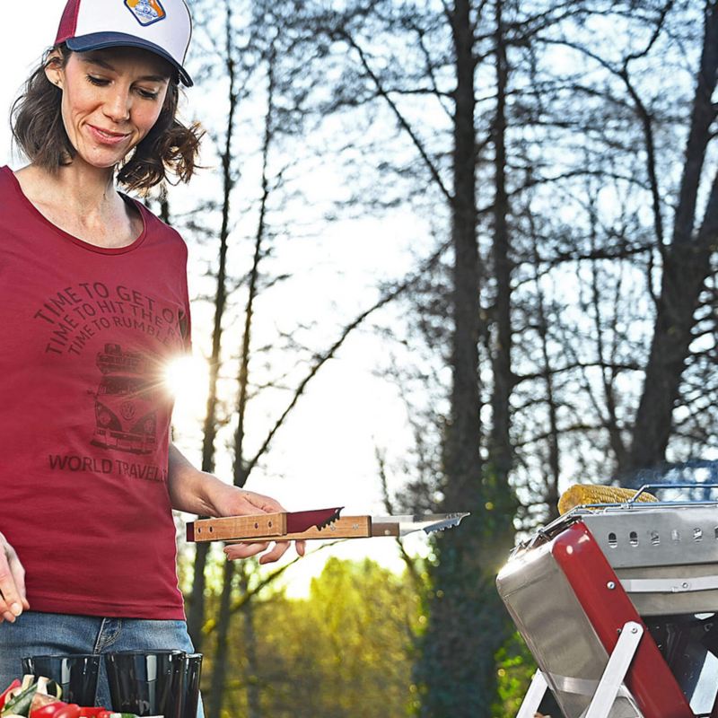 A person standing by a VW barbecue wearing merchandise
