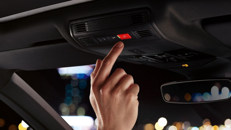 A driver pushing a button on the overhead console