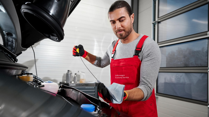 A mechanic checking the oil from a van