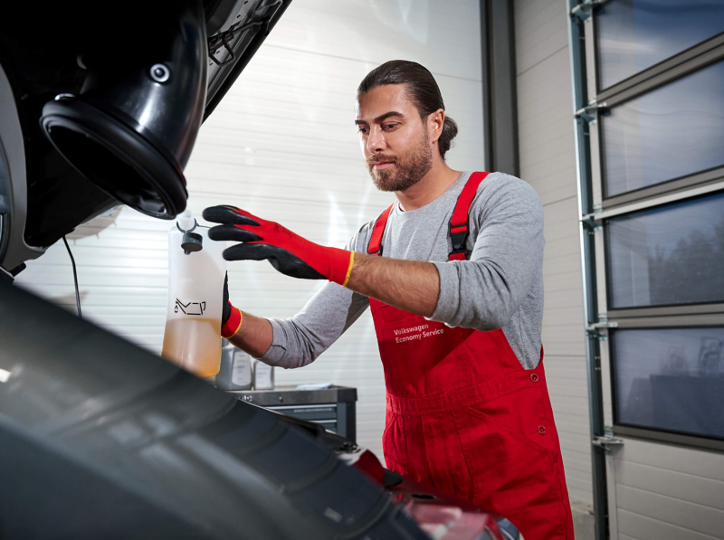 VW technician working on a van battery