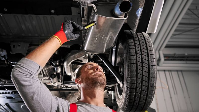 A VW technician inspecting a vehicle