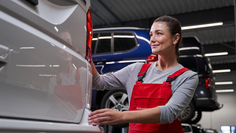 VW technician inspecting a VW Van. 