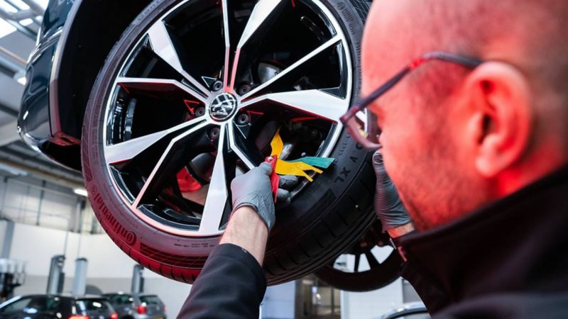 A technician checking the brake discs on a VW wheel