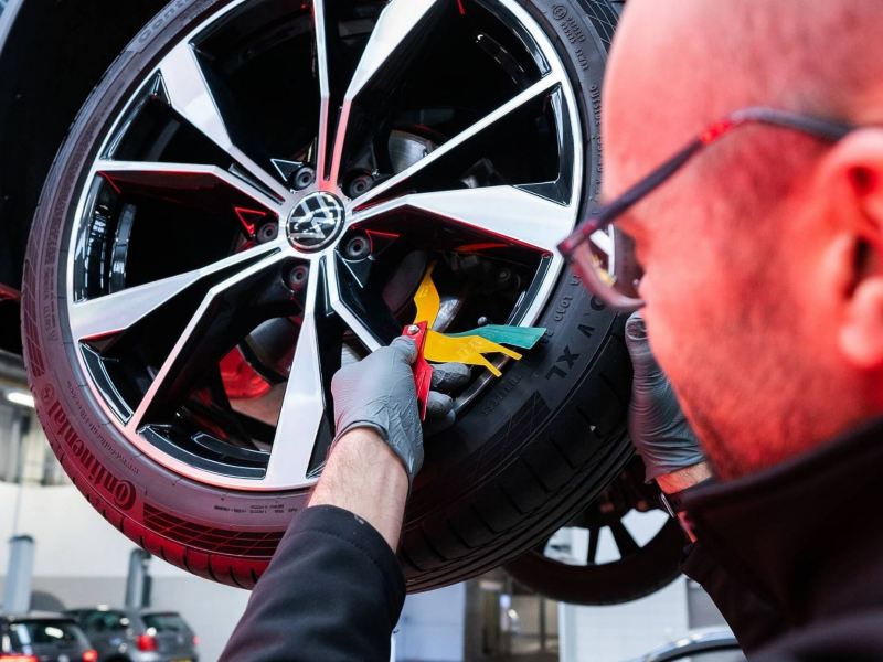 a close up of a mechanic working on a wheel