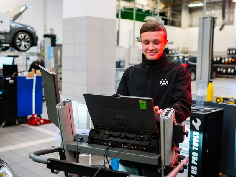 VW mechanic doing some car diagnostics on a laptop