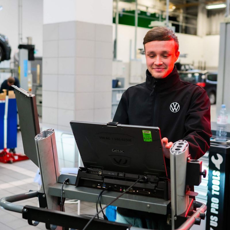 VW mechanic doing some car diagnostics on a laptop