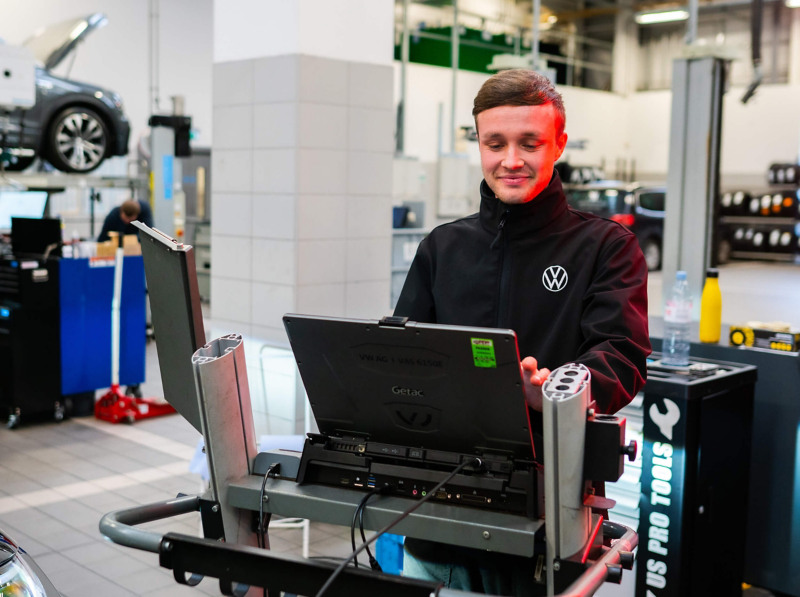 VW mechanic doing some car diagnostics on a laptop