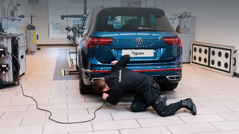 VW mechanic inspecting a VW car in a workshop