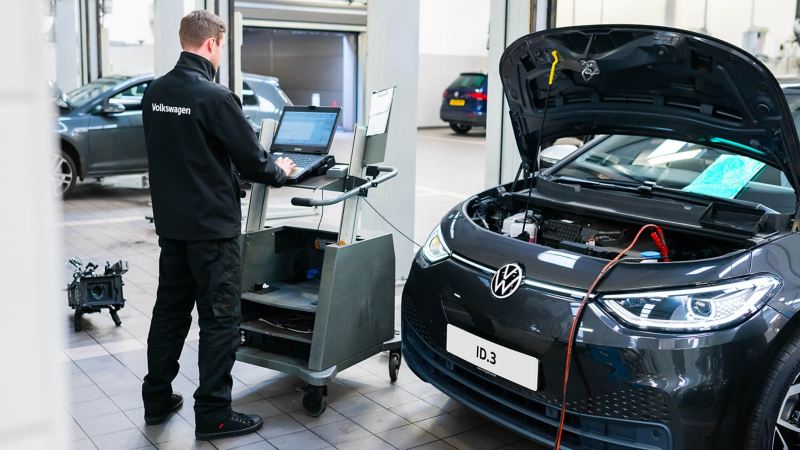 A technician typing into a computer plugged into a VW ID.3