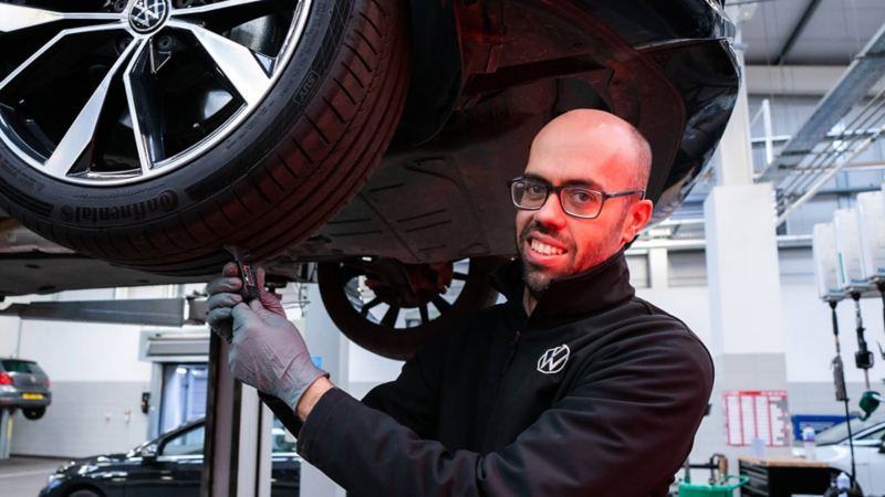 A Volkswagen technician checking a tyre tread