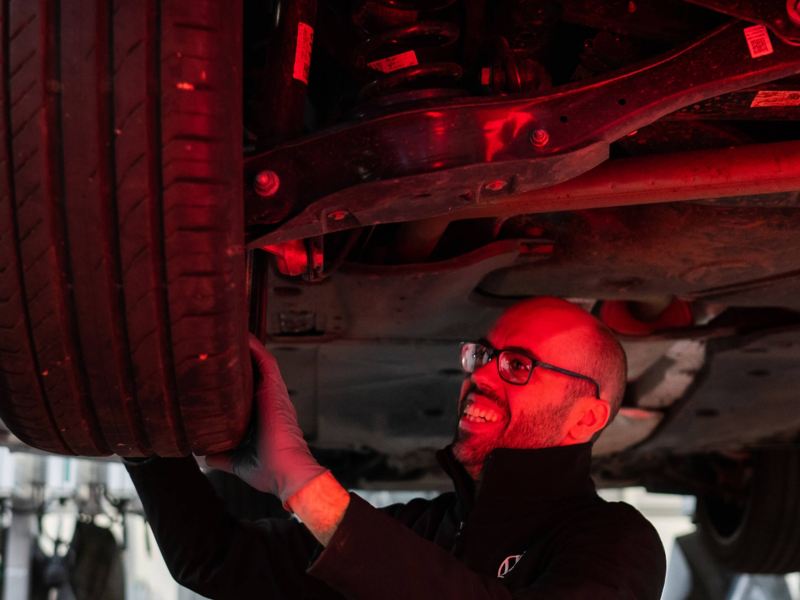 A VW technician inspecting a tyre