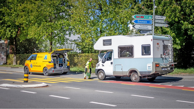 TCS Patrouillenfahrzeug bei einer Pannenhilfe an einem Wohnmobil am Strassenrand.